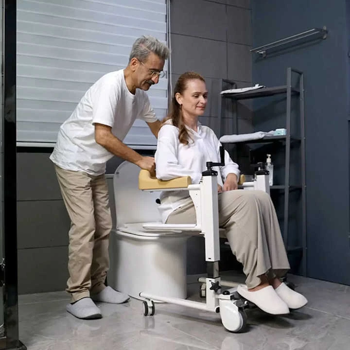 Caregiver transferring patient from shift chair onto home toilet